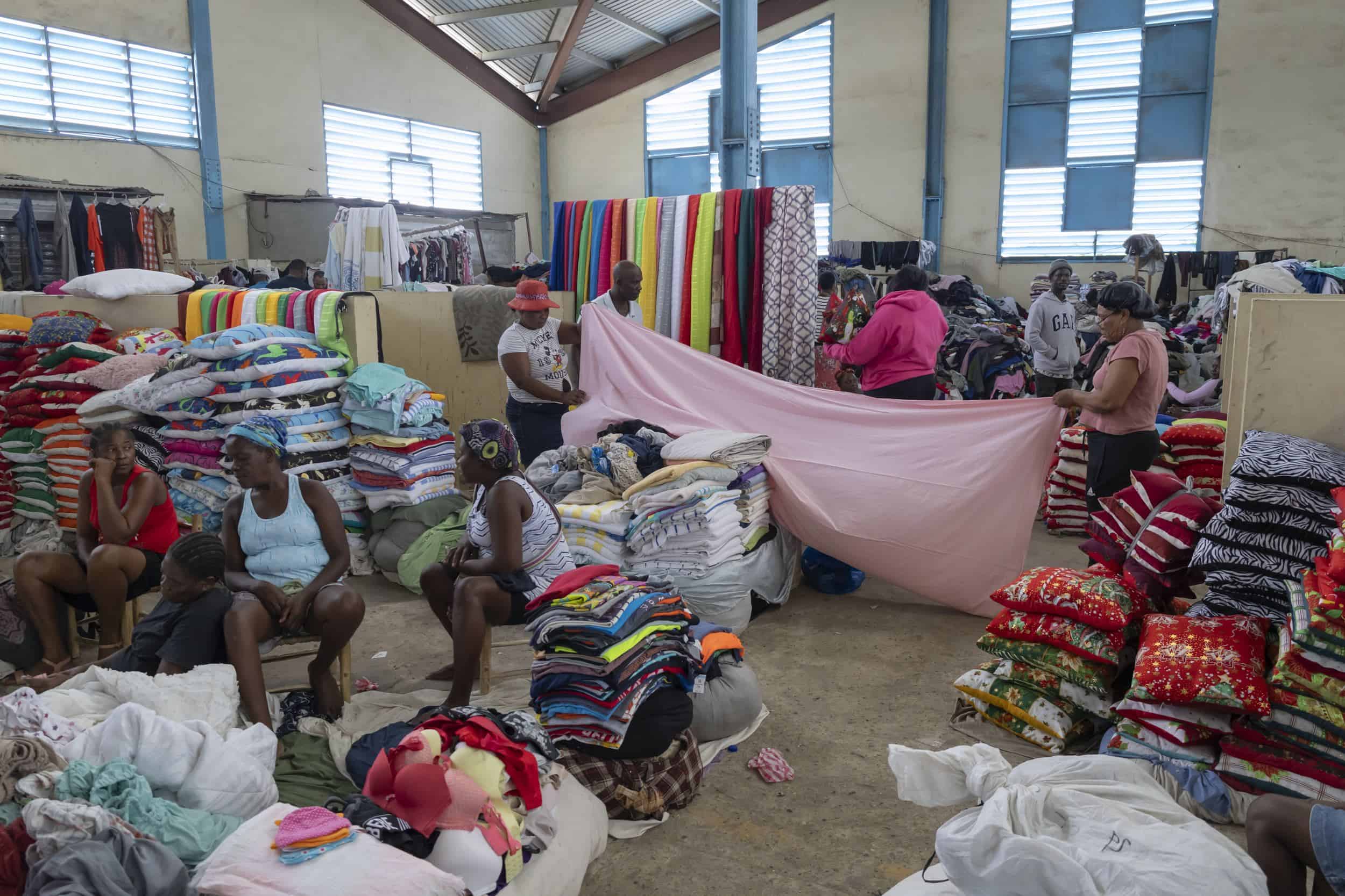 Dos mujeres extienden una tela rosa en el mercado de Dajabón.