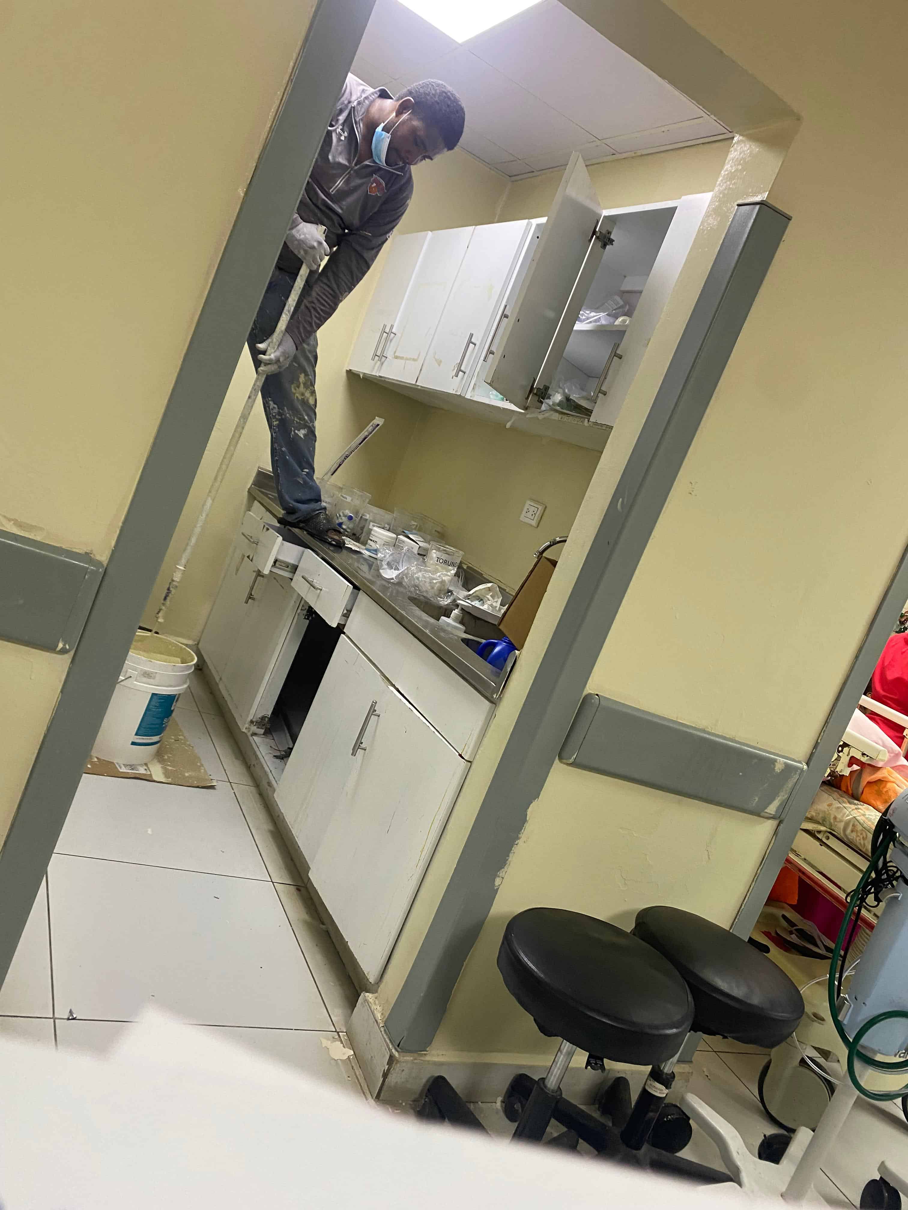Pintando en área de emergencia de adultos aborratada de pacientes, mayoría envejeciente, mezclado en el área de insumos médicos.