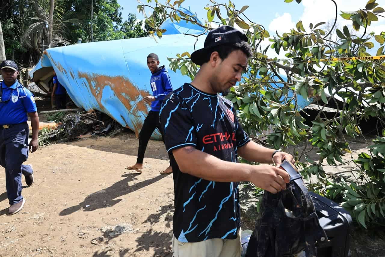 Brian Alexander, uno de los afectados tratando de recuperar ropas y otros objetos tras el derrumbe de la vivienda.