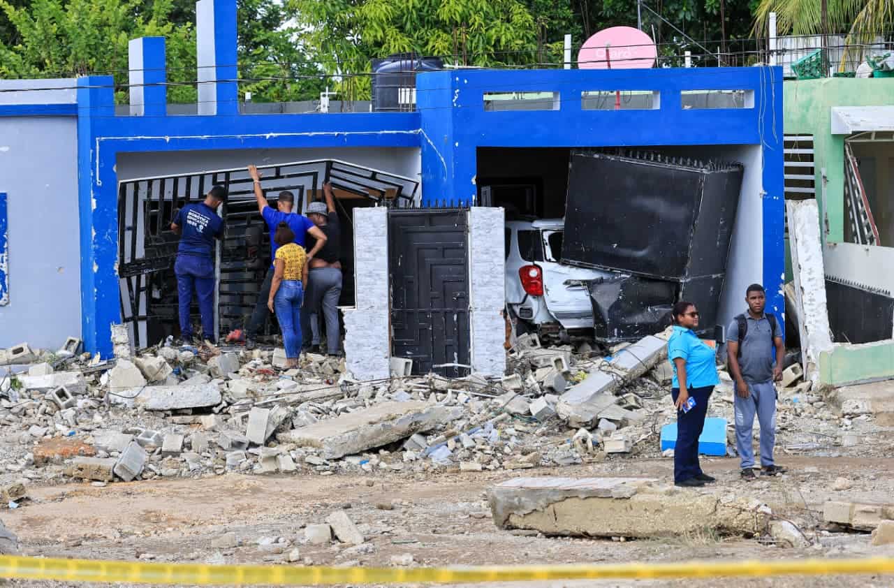 Richard Crispín junto a otros vecinos recogen entre los escombros lo que quedó de la vivienda de sus padres