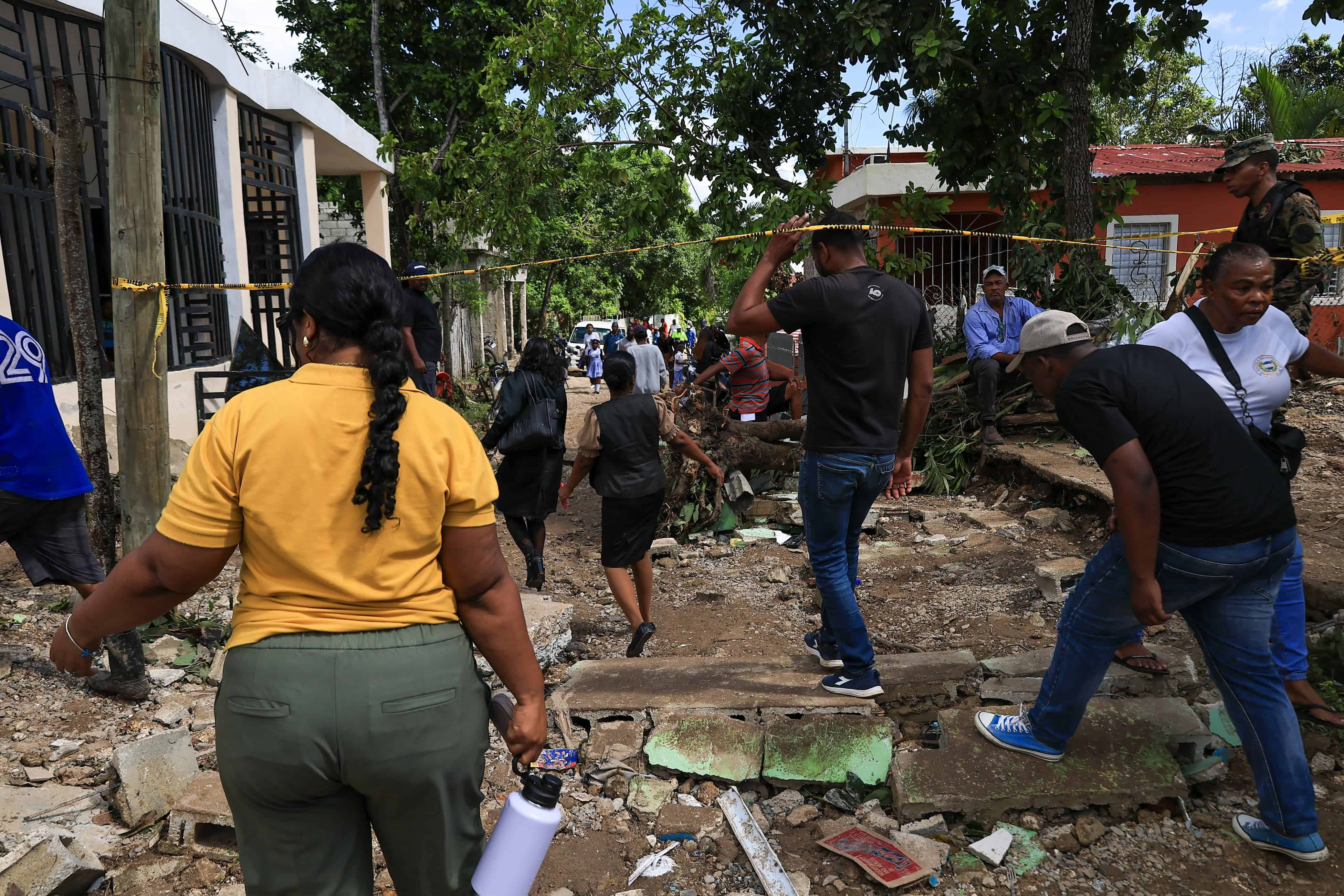 Comunitarios caminan entre los escombros.
