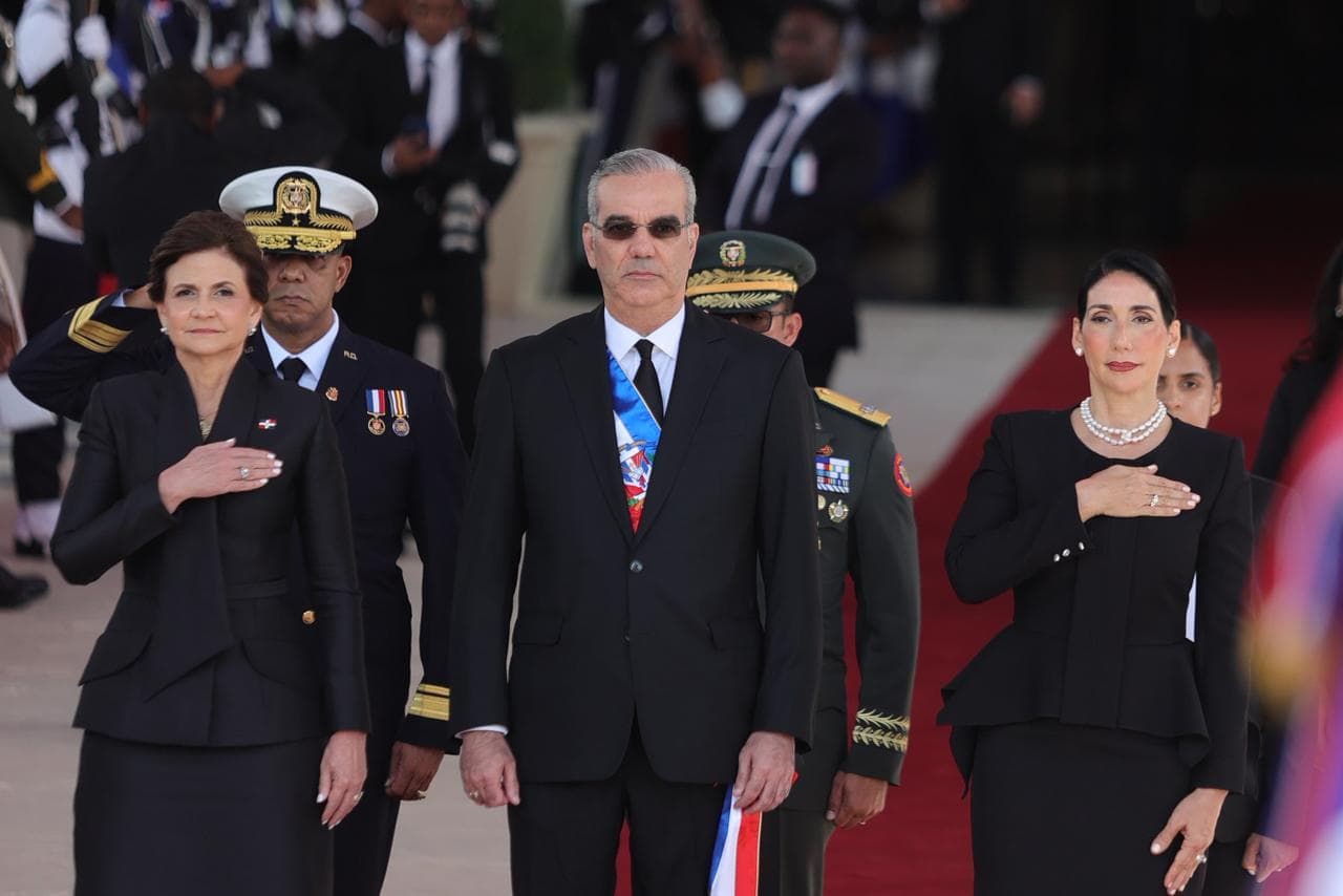 El presidente Luis Abinader durante la entonación del Himno Nacional a su llegada al Congreso, acompañado por la primera dama Raquel Arbaje (derecha) y la vicepresidenta Raquel Peña (izq.).