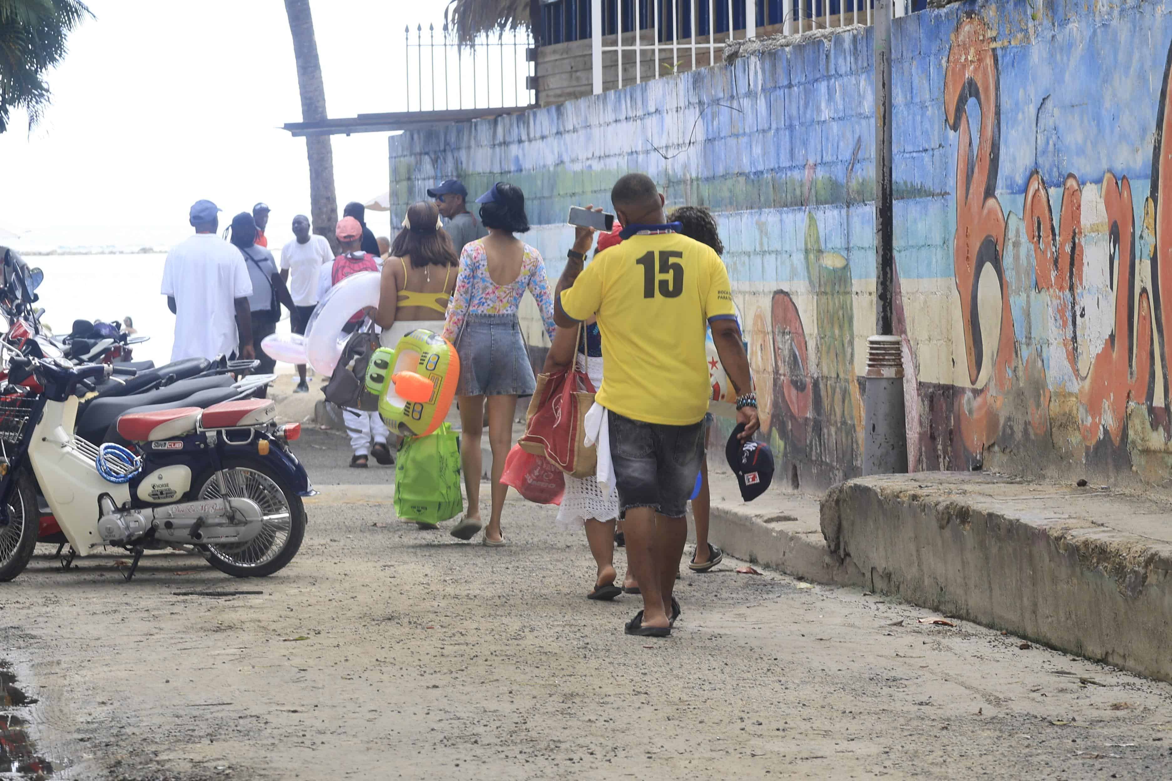 Visitantes llegan con bultos y neveras, llevando su propia comida para evitar gastar de más.