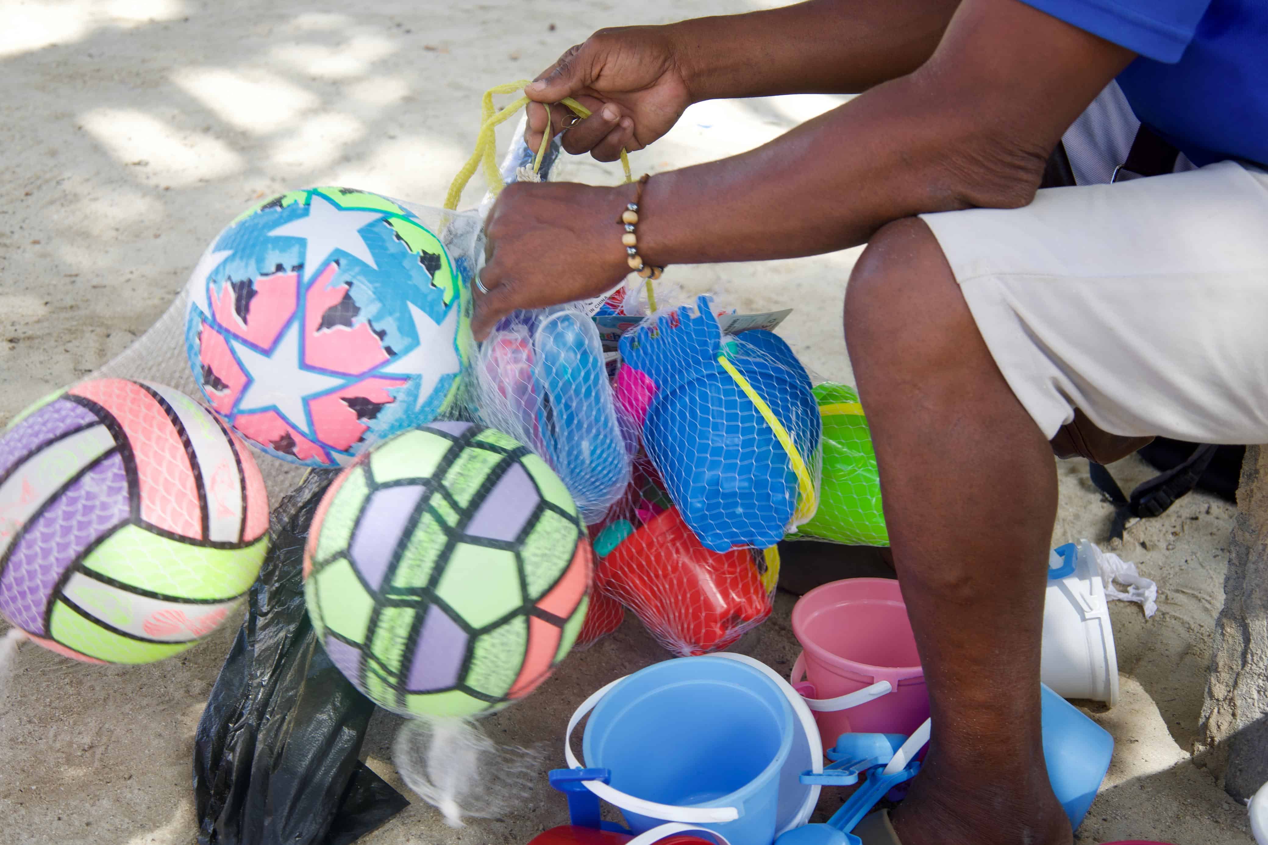 Pelotas, cubetas y otros juguetes son utilizados por niños para jugar en la arena