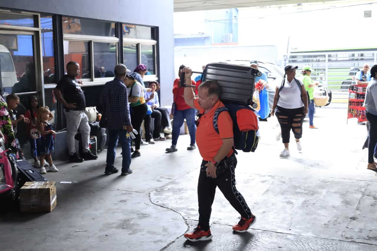 Un señor arriba con una maleta al hombro a una de las paradas de la región Este.