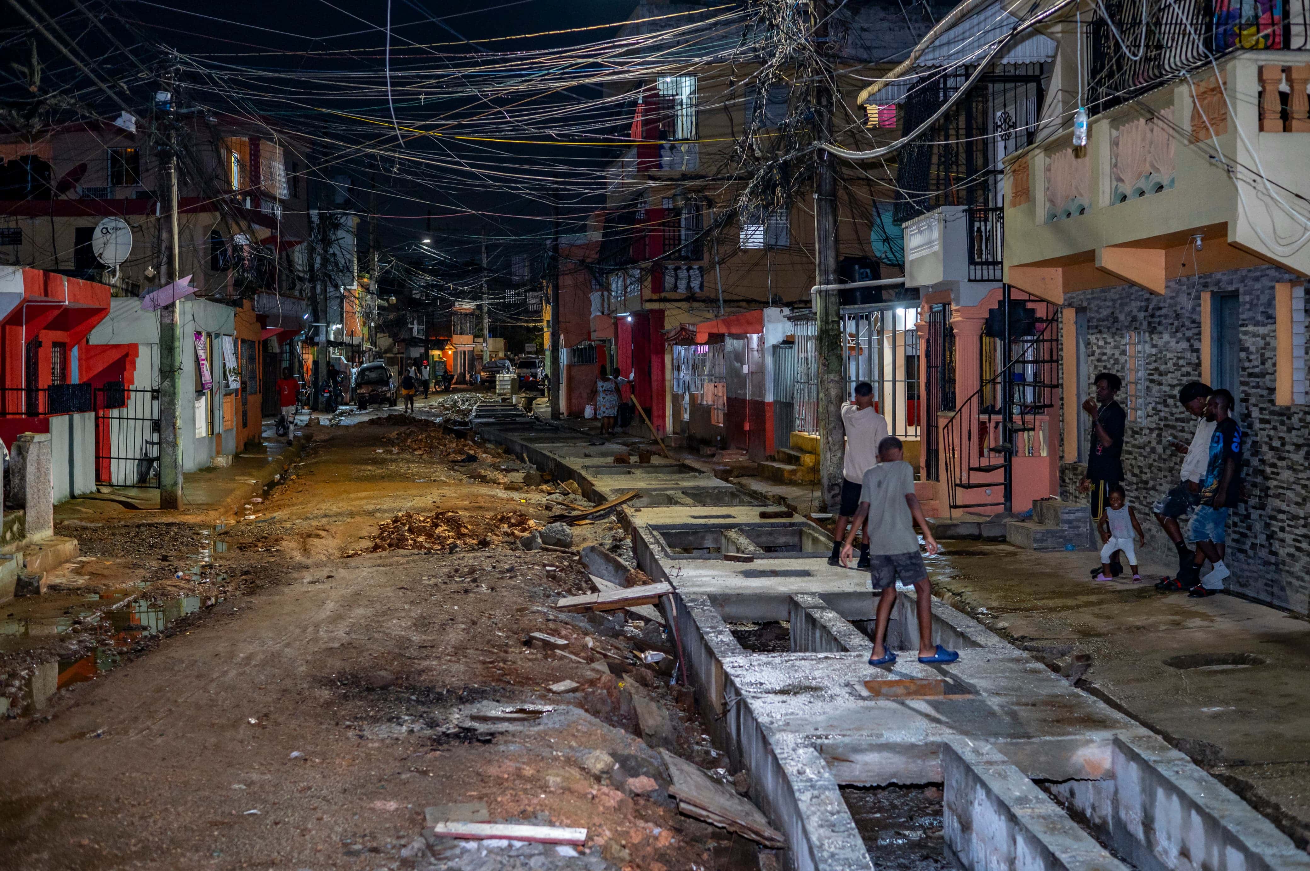 Un niño camina por encima del sistema de desagüe en construcción.