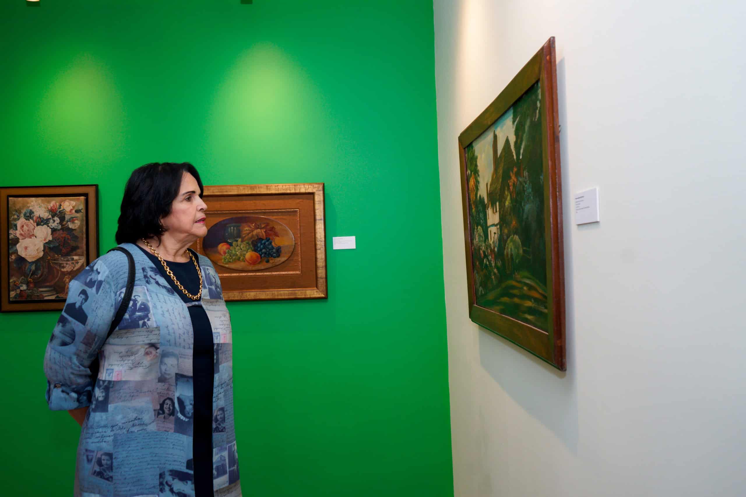 Minou Tavárez Mirabal observa las obras de la exposición “Un siglo: la dimensión artística de Minerva Mirabal”, en el Centro Cultural Banreservas Santiago.