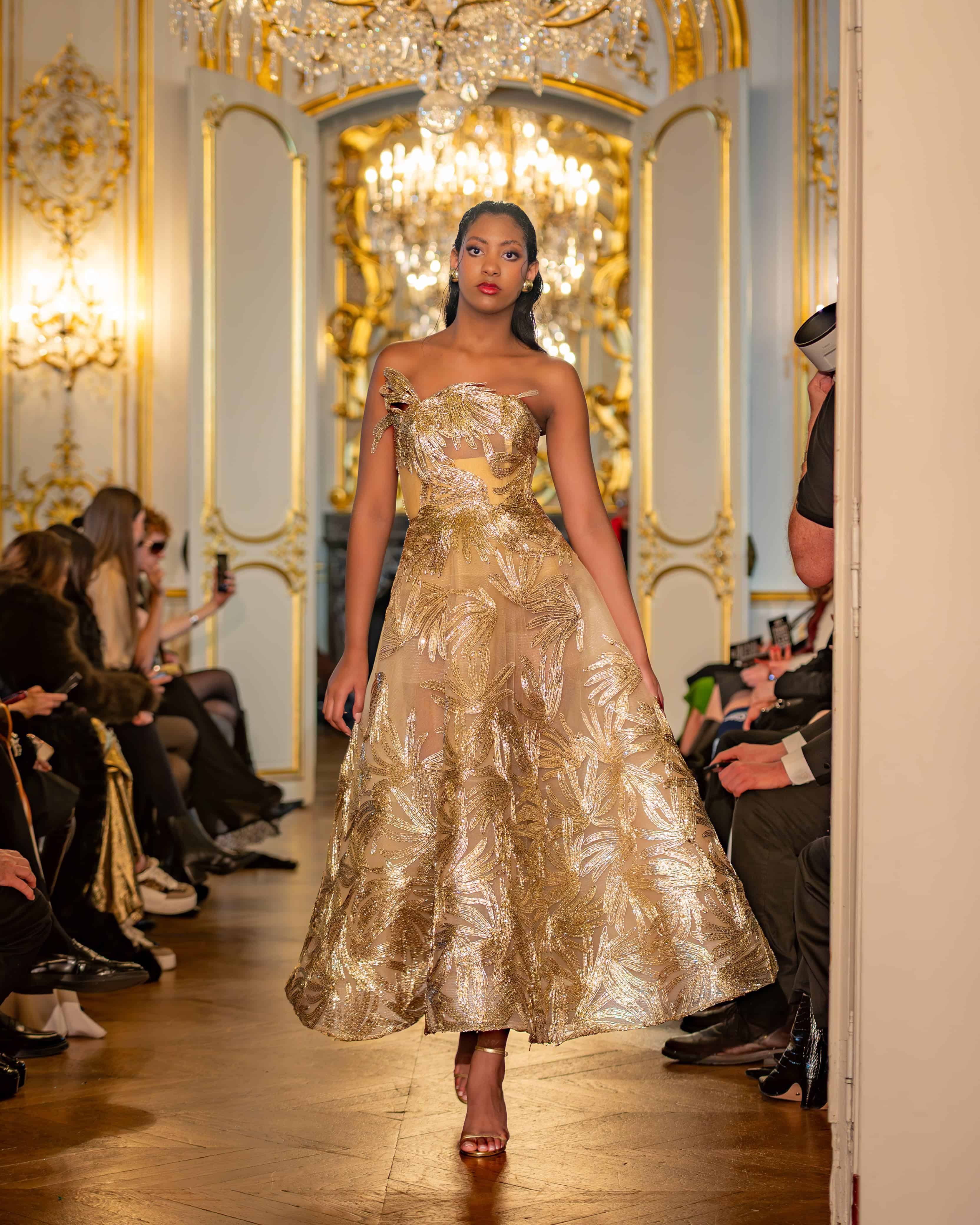 Una modelo desfila con piezas de la colección juvenil de Rafael Rivero, creada en colaboración con Idelkis Yeara e inspirada en las mariposas del Jardín Secreto de la Reina Charlotte de Bridgerton. Fantasía, color y delicadeza en cada detalle.