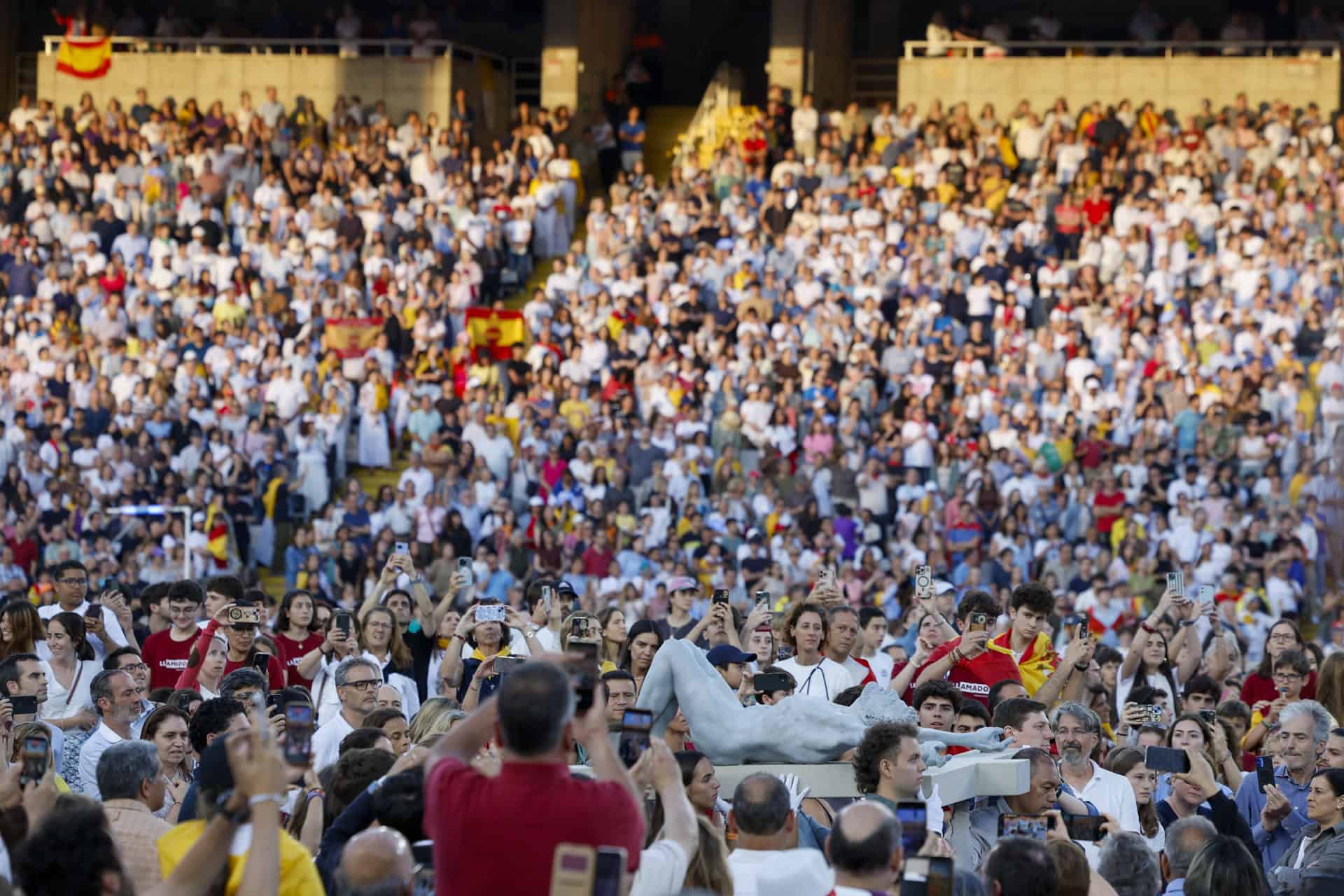 Varios jóvenes portan una cruz durante la vigilia que celebra el papa León XIV con 40.000 personas este martes en el Estadio Olímpico de Barcelona. 