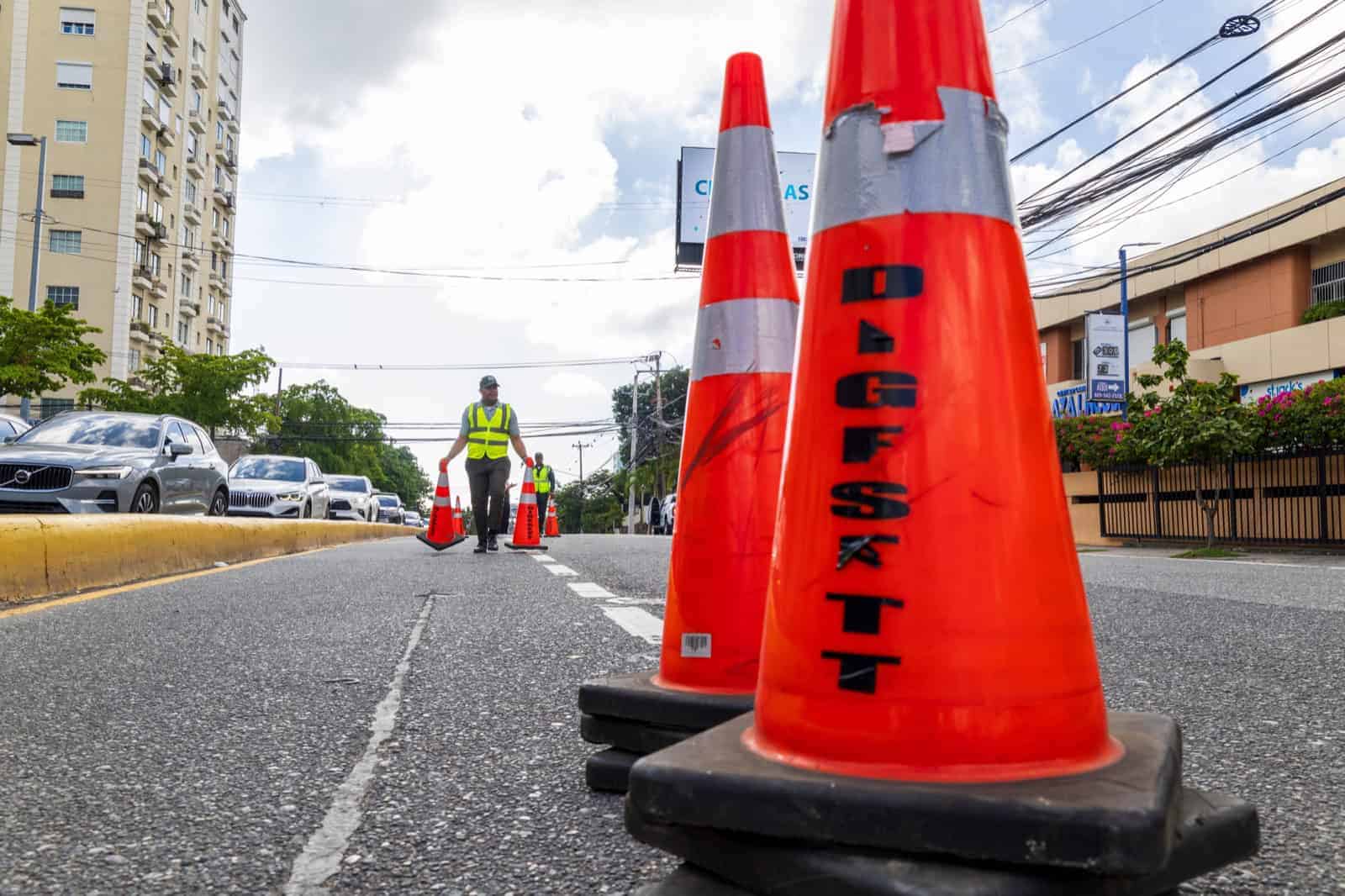 Un agente retirando los cono de carriles temporales que permiten agilizar el flujo vehicular.