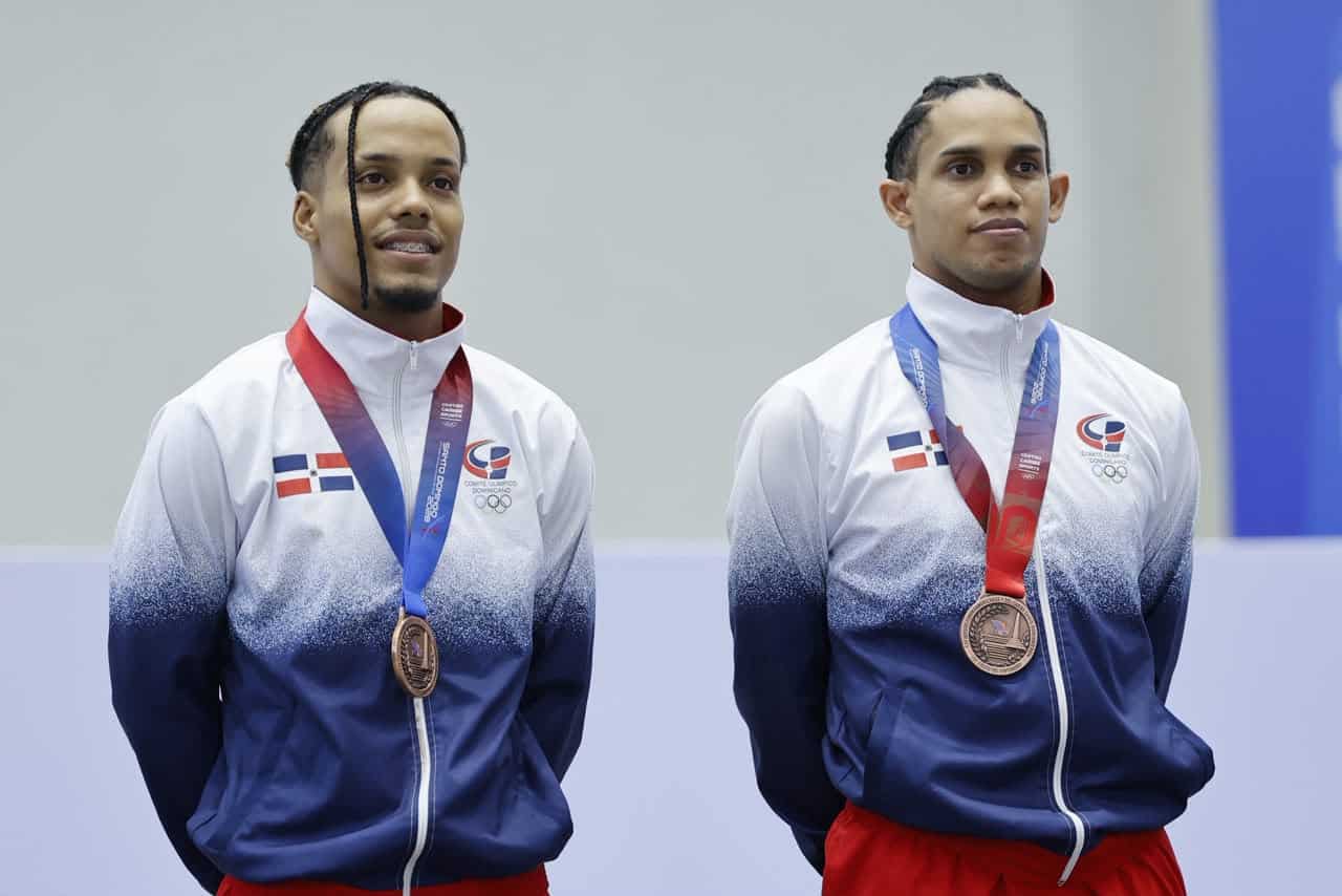 Los gimnastas dominicanos Emil De La Rosa y Junior Zapata con sus medallas de bronce tras subir al podio en la competencia de gimnasia trampolín.