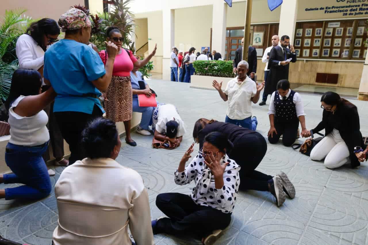 Familiares de los médicos imputados permanecen en oración en los alrededores del Palacio de Justicia. 