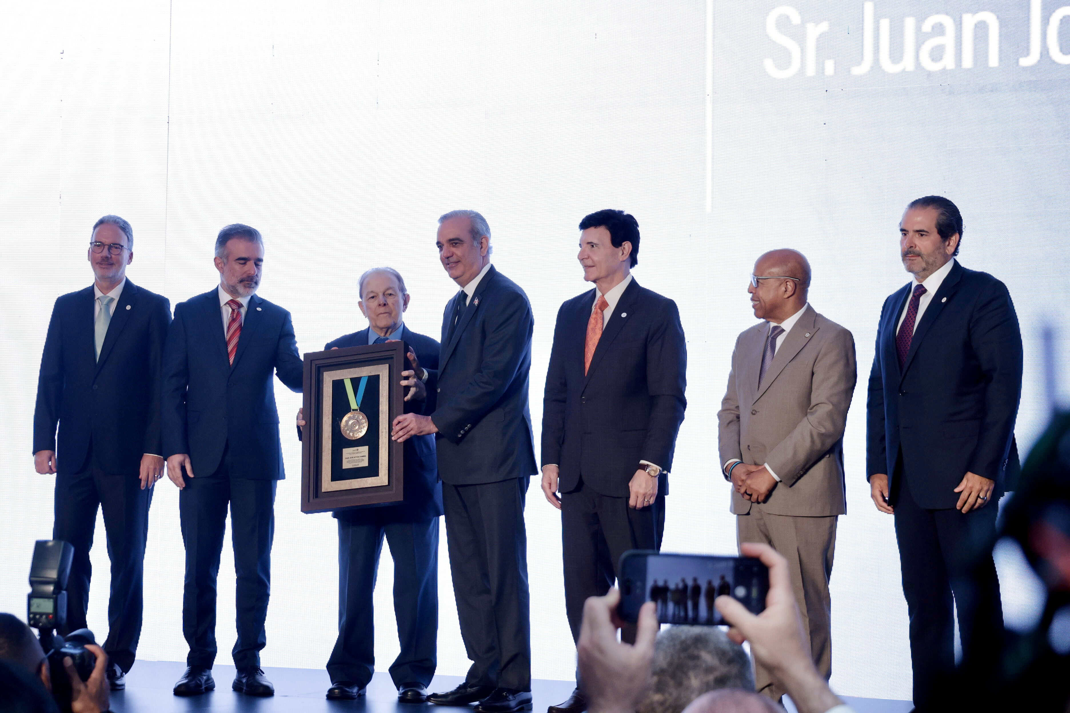 El empresario Juan José Attias Hamna (tercero de izquierda a derecha) recibe el galardón de manos del presidente de la República, Luis Abinader.