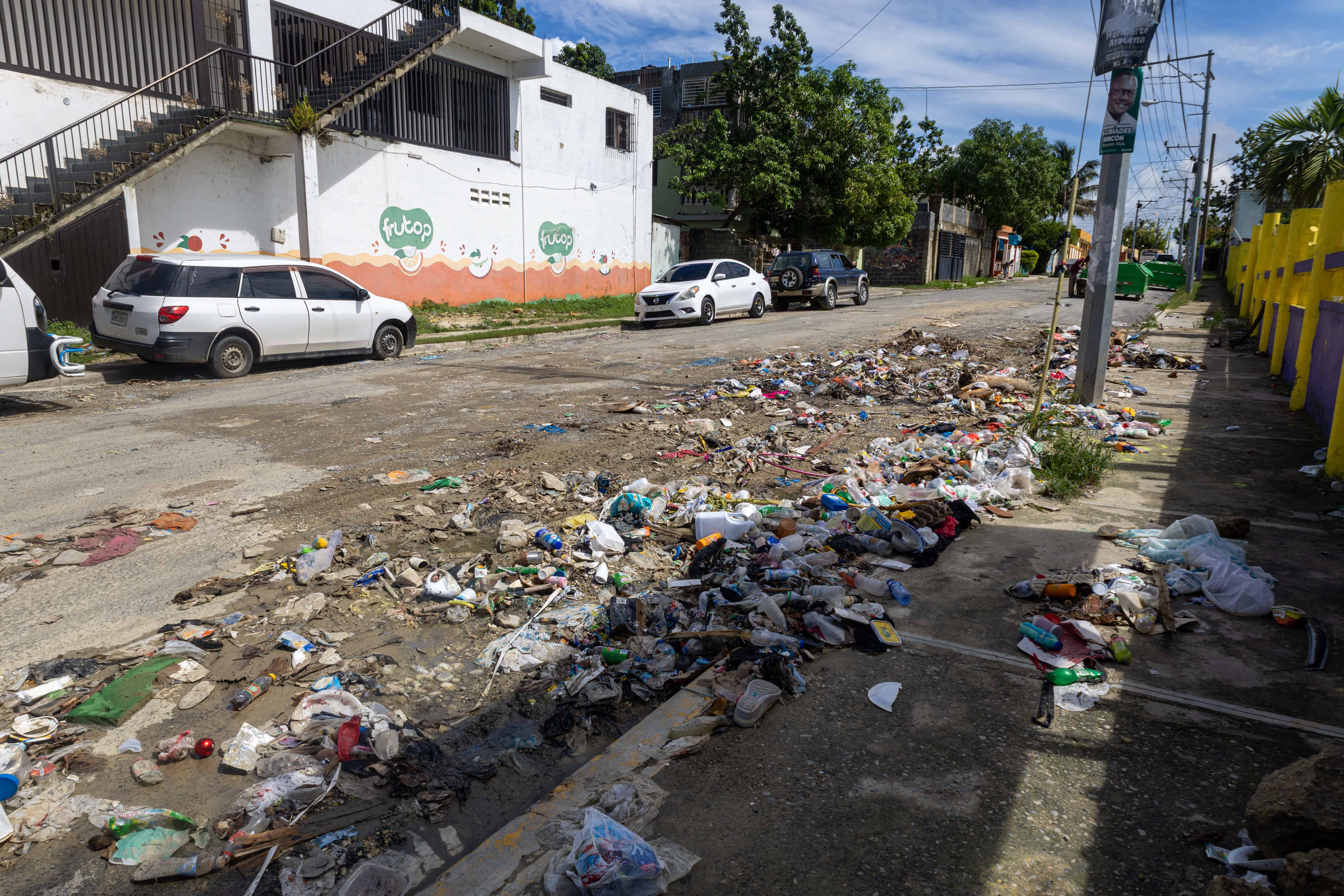 Restos de basura y distintos tipos de plásticos permanecían esparcidos en un tramo de la calle Francisco Peña Gómez, en San Luis.
